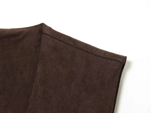 Détail de la texture en daim marron foncé et des coutures de haute qualité sur le vêtement