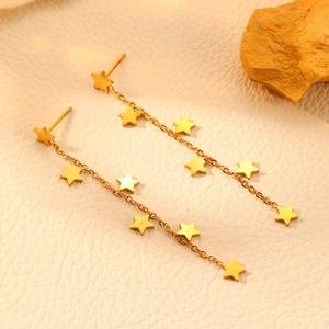 Elegant 18k gold plated stainless steel star tassel earrings set against stone and leather