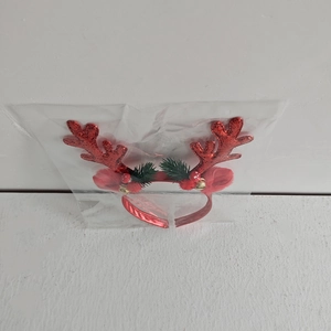 Detail of red Christmas reindeer antler headband with bells and sequins in packaging