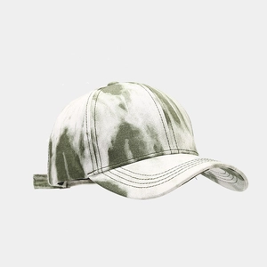 Détail d'une casquette de baseball tie-dye avec texture verte et coutures sur la visière