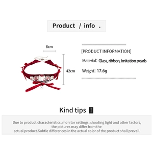 Détail d'un choker en velours rouge avec cristaux de verre, nœud et pendentif perle