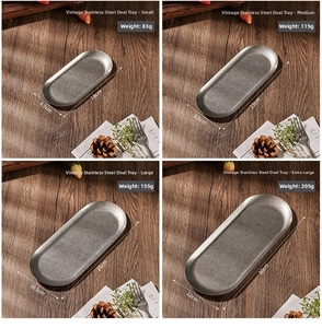 Four sizes of vintage oval stainless steel trays shown on a rustic wooden table