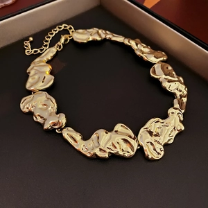 Detailed macro view of the irregular gold-tone links with molten lava texture and lobster clasp