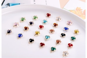 Macro shot of colorful crystal heart pendants in a white bowl for DIY jewelry making