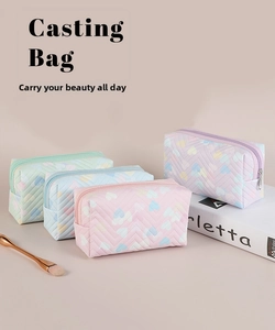 Detail of colorful heart prints on quilted PVC cosmetic bags in four macaron colors