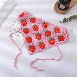 Detail of pink handmade crochet bandana with strawberry pattern and knit textures