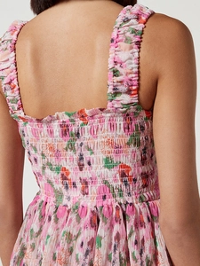 Detail of pink floral dress featuring elastic smocking and ruffle shoulder straps