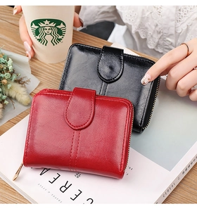 Detailed shot of two PU leather bifold wallets in black and red with gold zippers