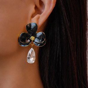 Détail de boucles d'oreilles fleurs en émail vintage avec pierre de zircon goutte d'eau