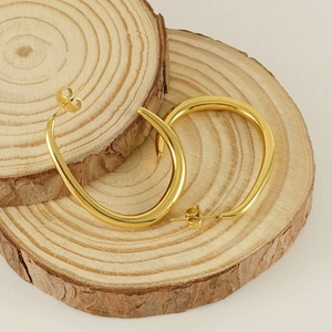 Minimalist gold U-shaped stainless steel earrings on wooden display with smooth finish