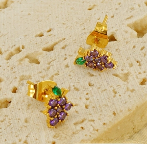 Macro detail of 18K gold plated grape earrings with purple and green zircon stones