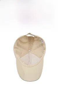 Detail view of khaki baseball cap featuring breathable mesh lining and laser-cut vent holes