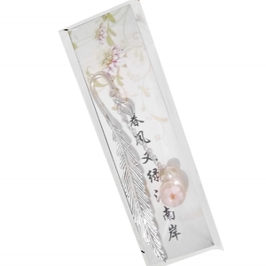 Silver metal feather bookmark with dried flower glass ball and pearl on white background