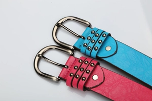Detail of blue and pink leather belts featuring punk style three-row rivets and metal buckles