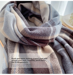 Close-up of thick plaid scarf texture in light blue and brown soft plush fabric