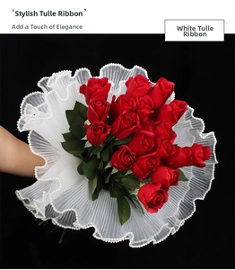 Detail of red roses wrapped in white pleated lace ribbon with elegant pearl edging