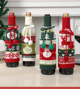 Detail of knitted Christmas wine bottle covers with reindeer and snowflake patterns