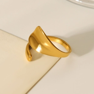 Close-up of a minimalist 18K gold plated organic wavy leaf ring on a neutral background