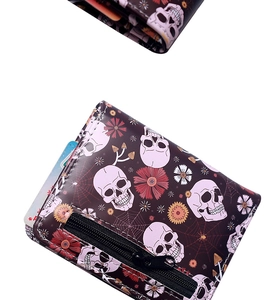 Detail of short wallet featuring spider web and skull print with zipper pocket