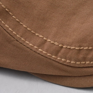 Detailed close-up of double-stitched brown canvas fabric showing high-quality sewing craftsmanship