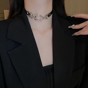 Détail d'un ras-de-cou en cuir noir avec chaîne argentée et perle sur mannequin