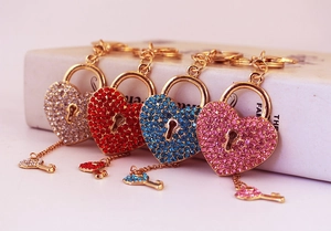 Macro view of rhinestone-encrusted heart lock and key keychain in multiple colors