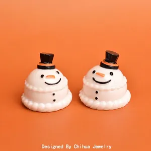 Figurines de bonhomme de neige miniatures en résine avec chapeaux hauts-de-forme sur fond orange