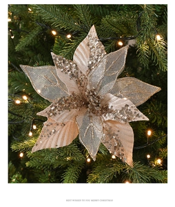 Close-up of champagne gold glitter poinsettia flower on a decorated Christmas tree