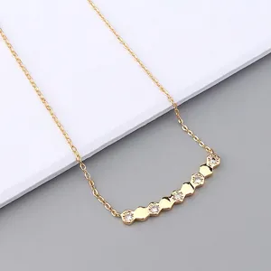 Detailed close-up of a gold hexagonal pendant necklace with micro-pave cubic zirconia stones