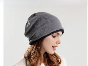 Detail of grey slouchy beanie featuring fine knit texture and black contrast hem