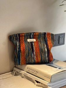 Detail der böhmischen gestreiften Web-Tasche mit Label auf einem Stapel Zeitschriften