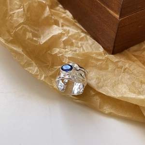 Irregular textured S925 sterling silver ring with oval blue gemstone and open band design