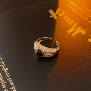 Macro detail of a vintage gold ring with brown stone and pavé zircons on a book