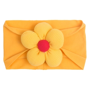 Close-up of baby nylon headband featuring a large yellow corduroy flower and red center