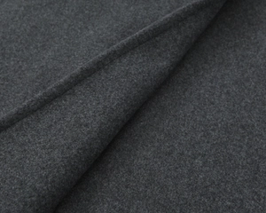 Détail macro du tissu en laine gris foncé montrant une texture douce et des fibres denses