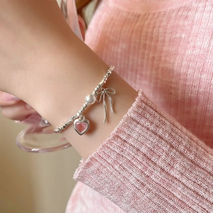 Silbernes Perlenarmband mit rosa Zirkon-Herz, Schleife und Perle am Handgelenk