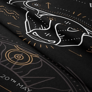 Detailed close-up of Taurus zodiac pattern on black fabric tapestry with gold printing