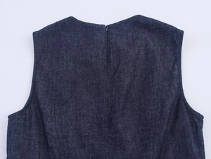 Détail du décolleté et de la fermeture éclair sur une robe midi en jean bleu foncé chic