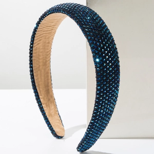 Deep blue padded headband with sparkling rhinestones on a minimalist white background