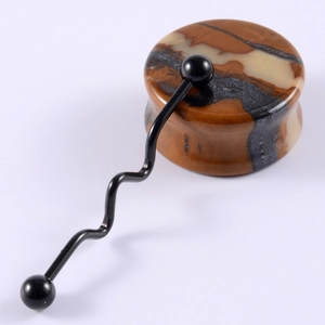 Close-up of stone ear gauge and black wave industrial barbell piercing on white background