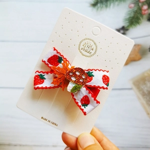 Handmade strawberry pattern bow hair clip with glitter mushroom accent on card