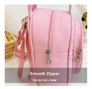 Pink kids backpack with double zipper and floral metal pendants in a side-angle view