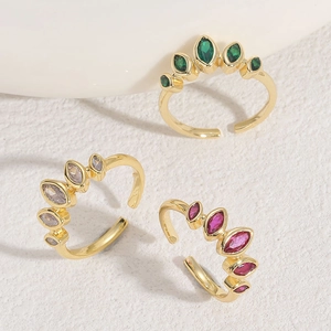 Detail shot of three 14K gold plated marquise-cut zircon open rings in green, white and red