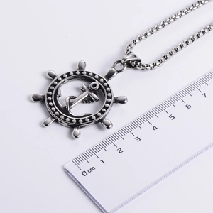 Collier vintage argenté avec pendentif ancre et gouvernail mesuré avec une règle