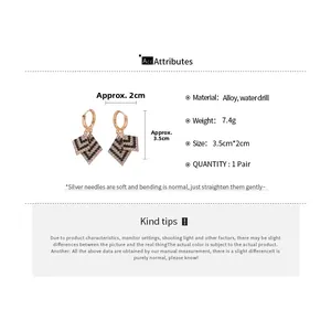 Vue détaillée de boucles d'oreilles losanges avec cristaux noirs et blancs en or rose poli