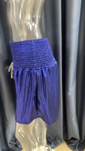 Macro detail of royal blue pleated shorts with metallic shimmer and elastic waistband