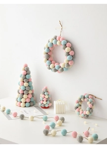 Close-up of handmade colorful wool felt ball Christmas trees and wreaths decorations