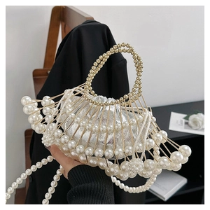 Close-up of pearl beaded handbag with golden frame and silver satin drawstring pouch
