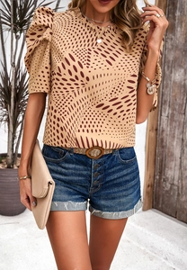 Beigefarbenes Oberteil mit roten Punkten, Puffärmeln und blauen Denim-Shorts mit Gürtel