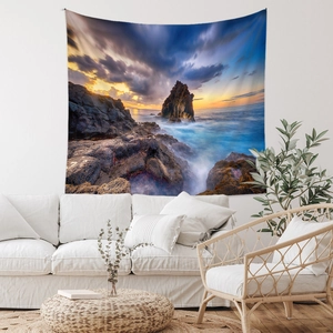 Détail d'une tapisserie bohème de coucher de soleil suspendue au-dessus d'un canapé blanc